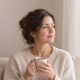 Woman sitting quietly with a cup of tea during the two-week wait after IVF